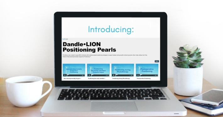 Laptop sitting on desk, with "Introducing: Dandle Lion Positioning Pearls" and four preview images of positioning pearl videos on the screen.